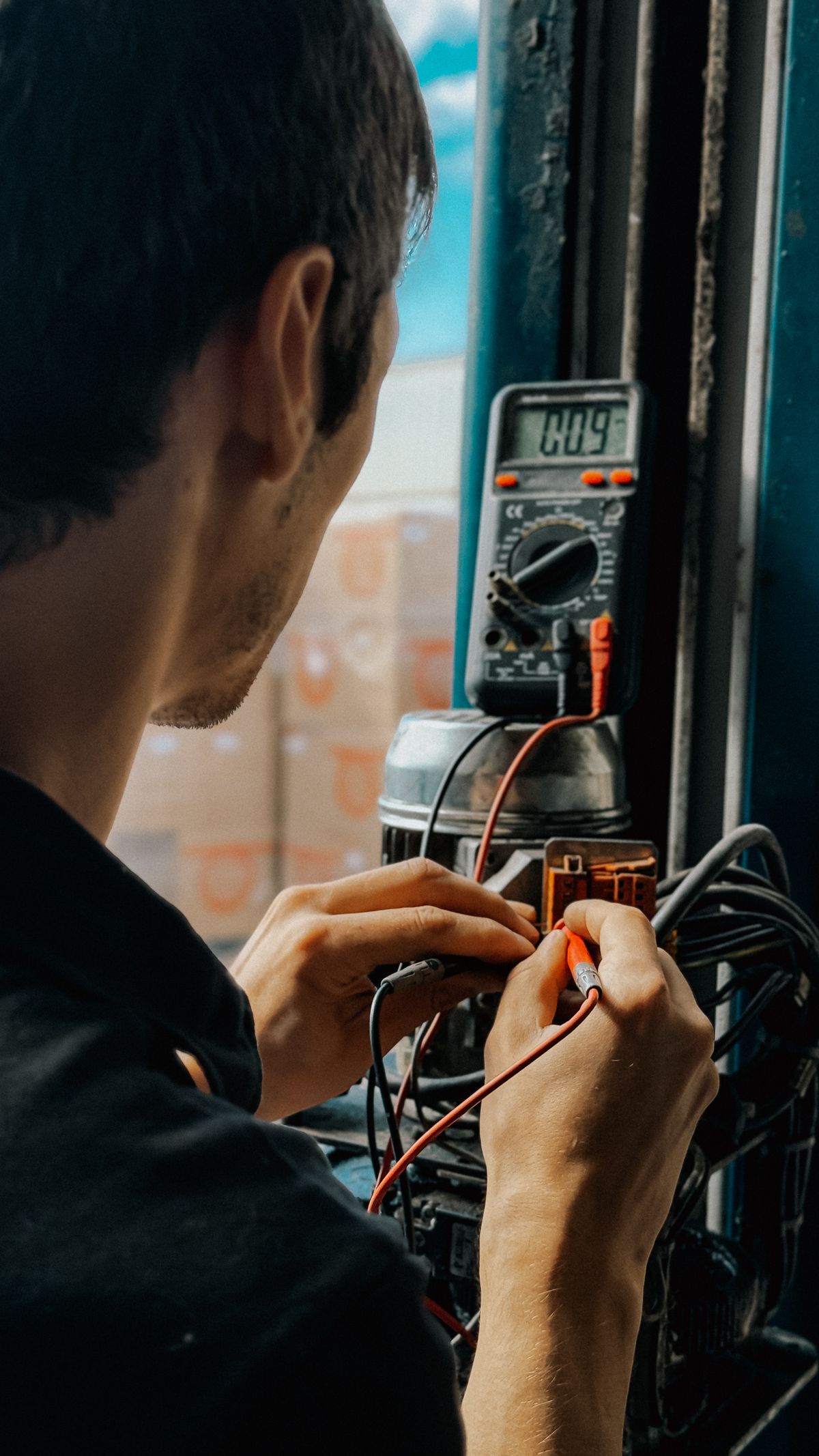 Electrician testing a panel with a multimeter